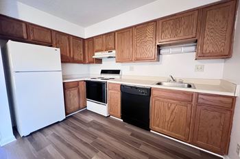 A kitchen with wooden cabinets and a white fridge.